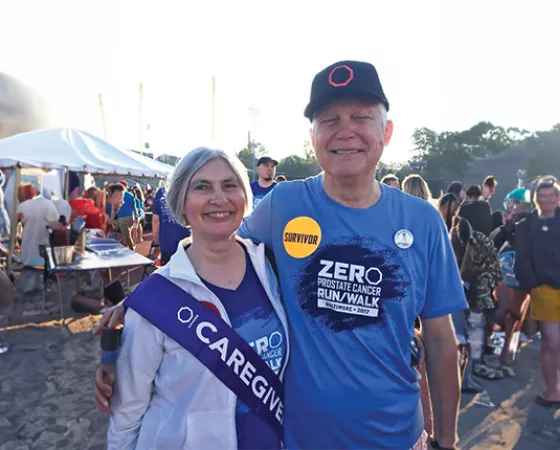 A prostate cancer survivor and his wife who is wearing a Caregiver sash at a Run/Walk event